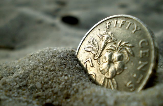 A coin half buried in the sand.