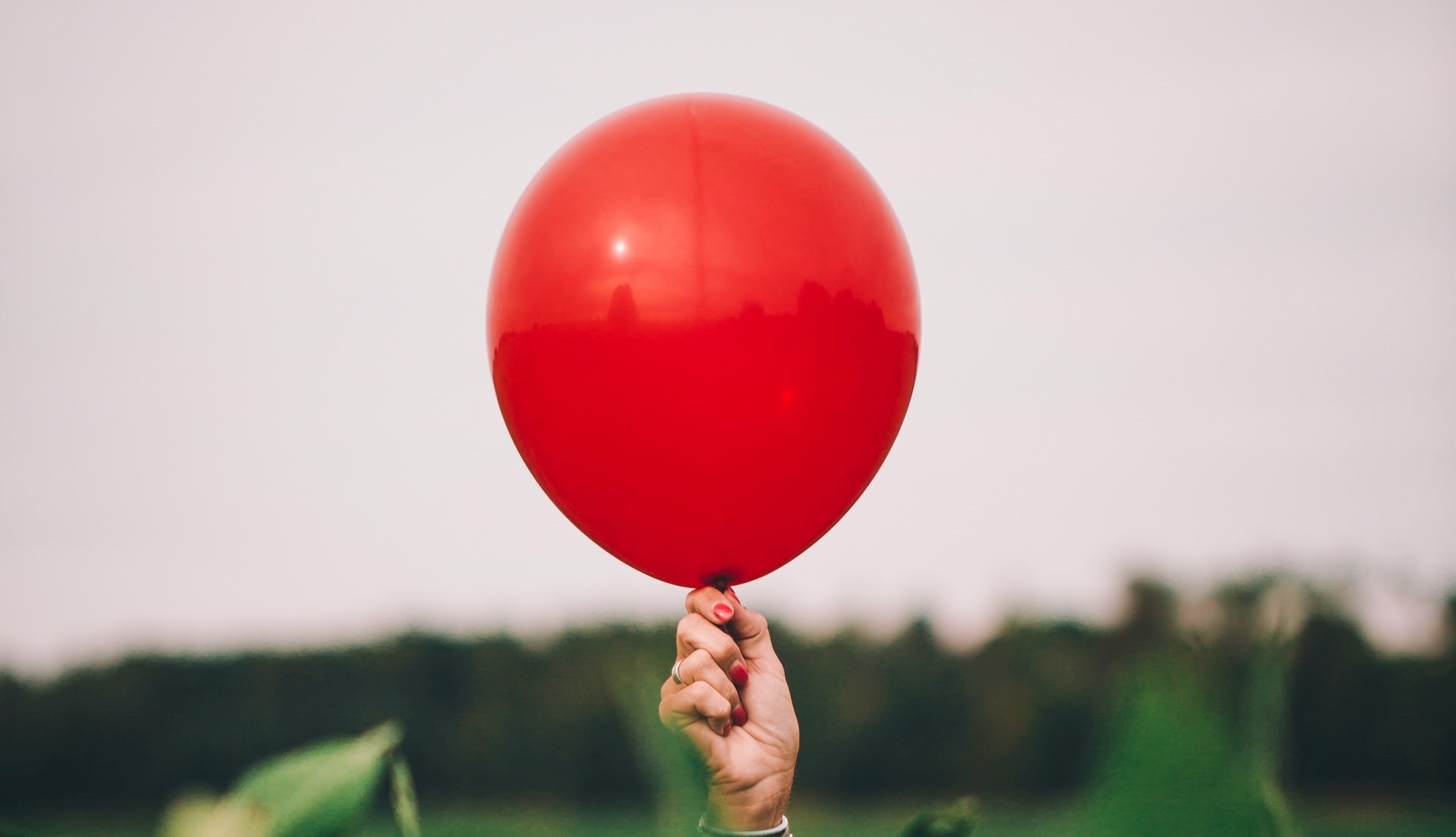A red balloon held by a hand.