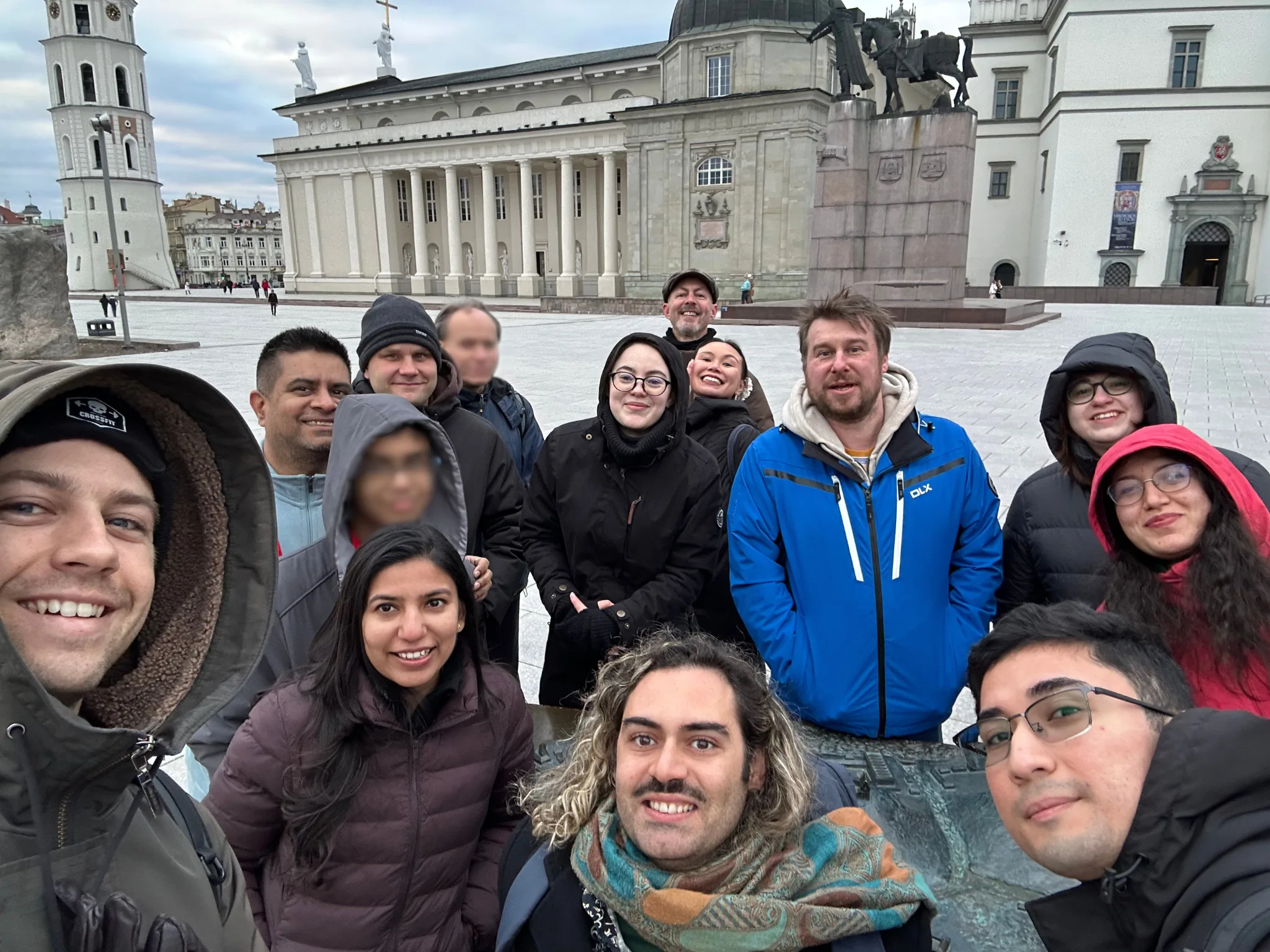 Some PyCon Lithuania speakers smile at the camera in front of Gediminas's castle.