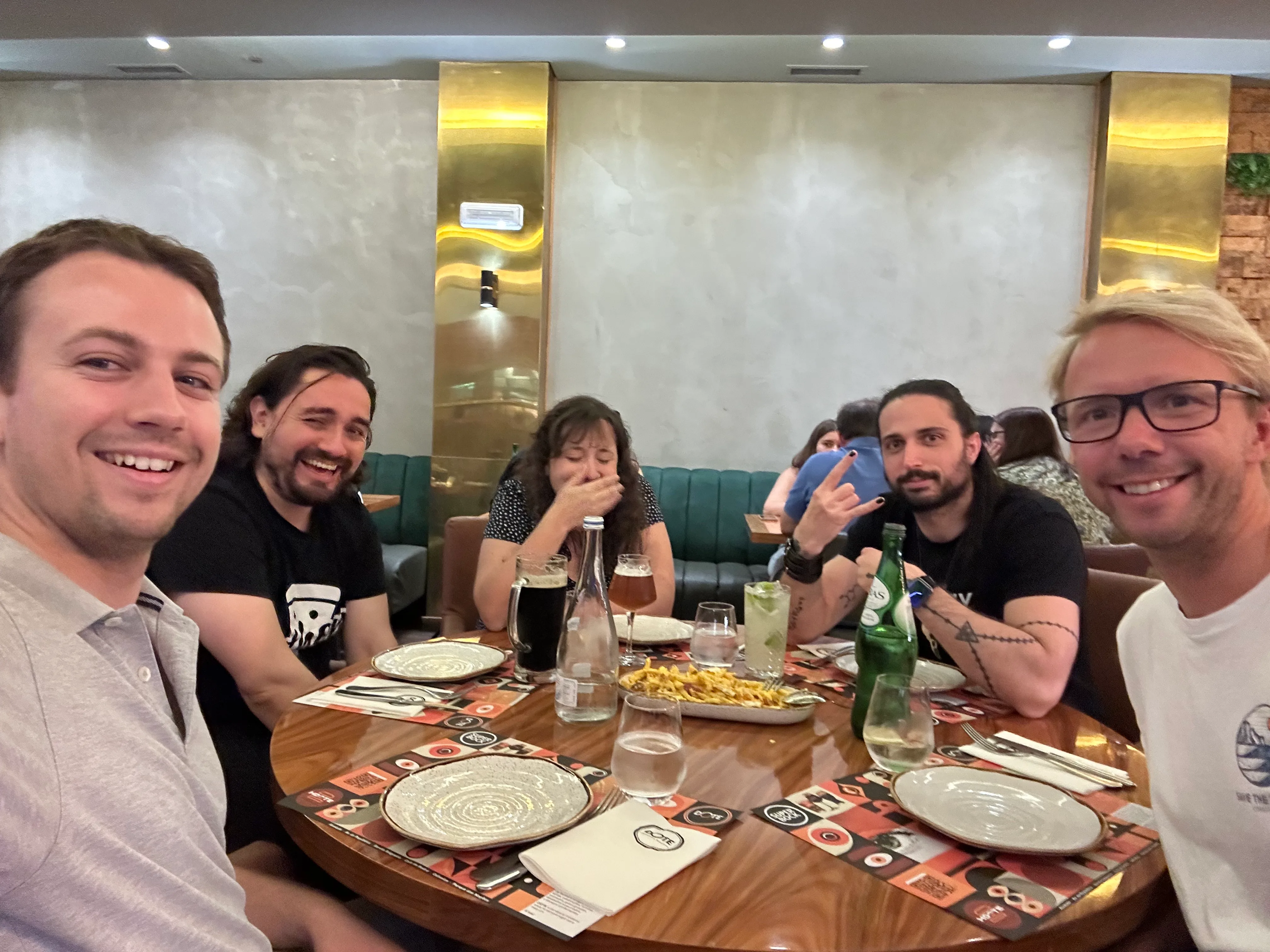 Selfie showing, from left to right, Rodrigo, Cristián, Maria José, Pablo, and Anže, around a circular table, waiting for dinner.