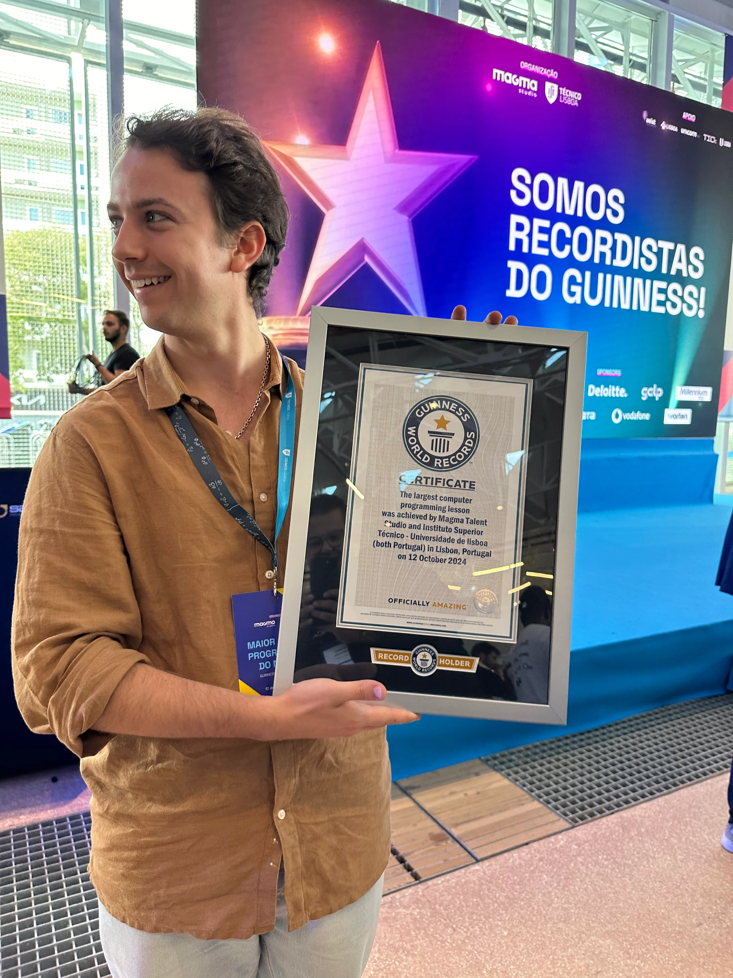 Photo of me looking to the side while holding the Guinness World Record certificate that attributes the record to the two institutions that organised the event.