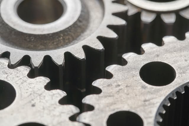 A close-up of three gears turning together